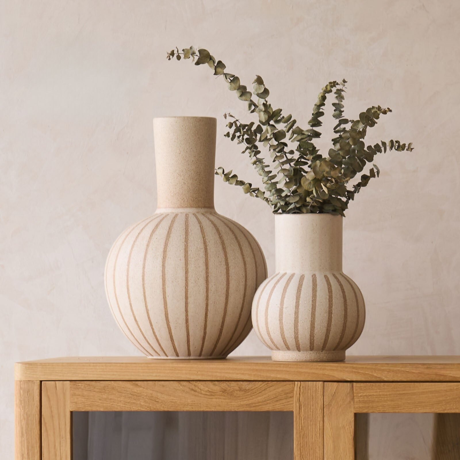 Sand-toned ceramic vases styled on a wooden console
